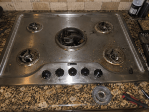 repairing the spark module on a Maytag gas stovetop.