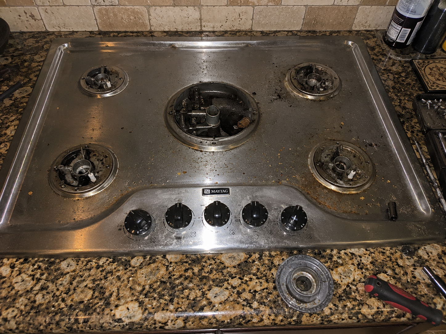 repairing the spark module on a Maytag gas stovetop.